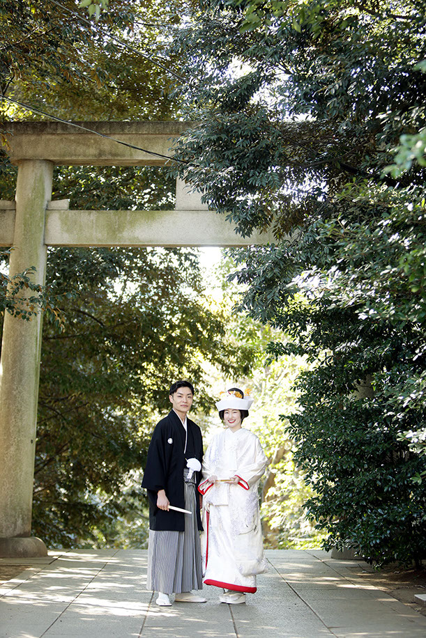 Y帝の玄関前で伏し目がちに微笑む新婦